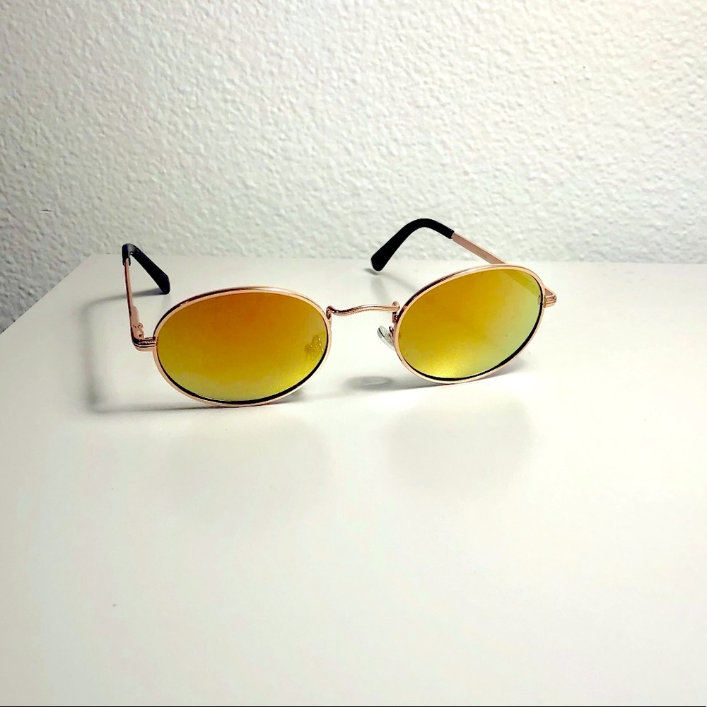 Unisex oval Polaroid sunglasses with orange and green hues and metal frame.